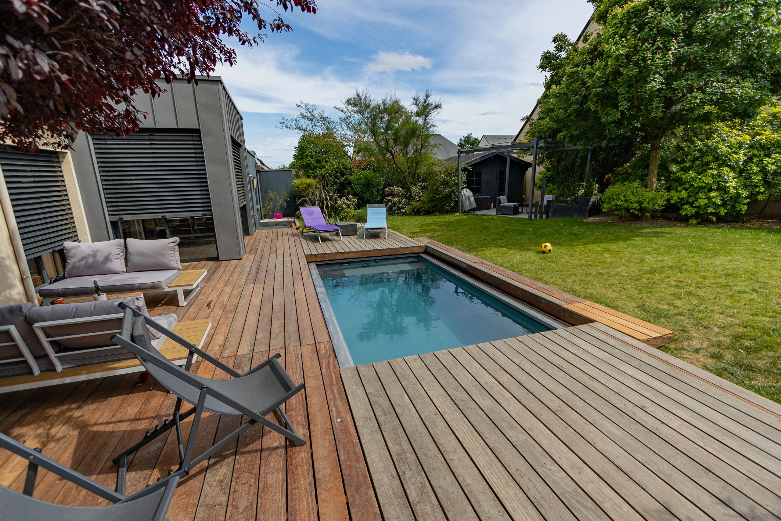 Spa de nage entouré d'une terrasse en ipé avec salon lounge, intégré dans un jardin moderne à Compiègne — Colver