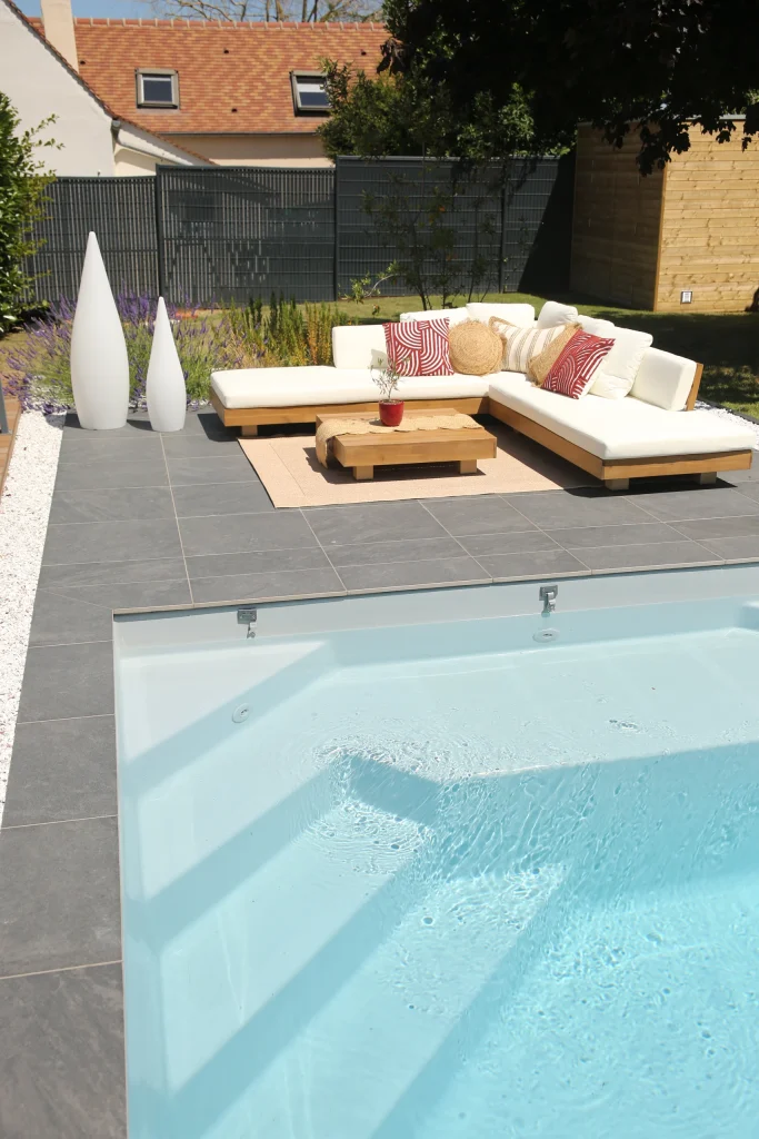 Terrasse en carrelage gris anthracite avec salon de jardin et piscine contemporaine — Colver Créateur de Jardin