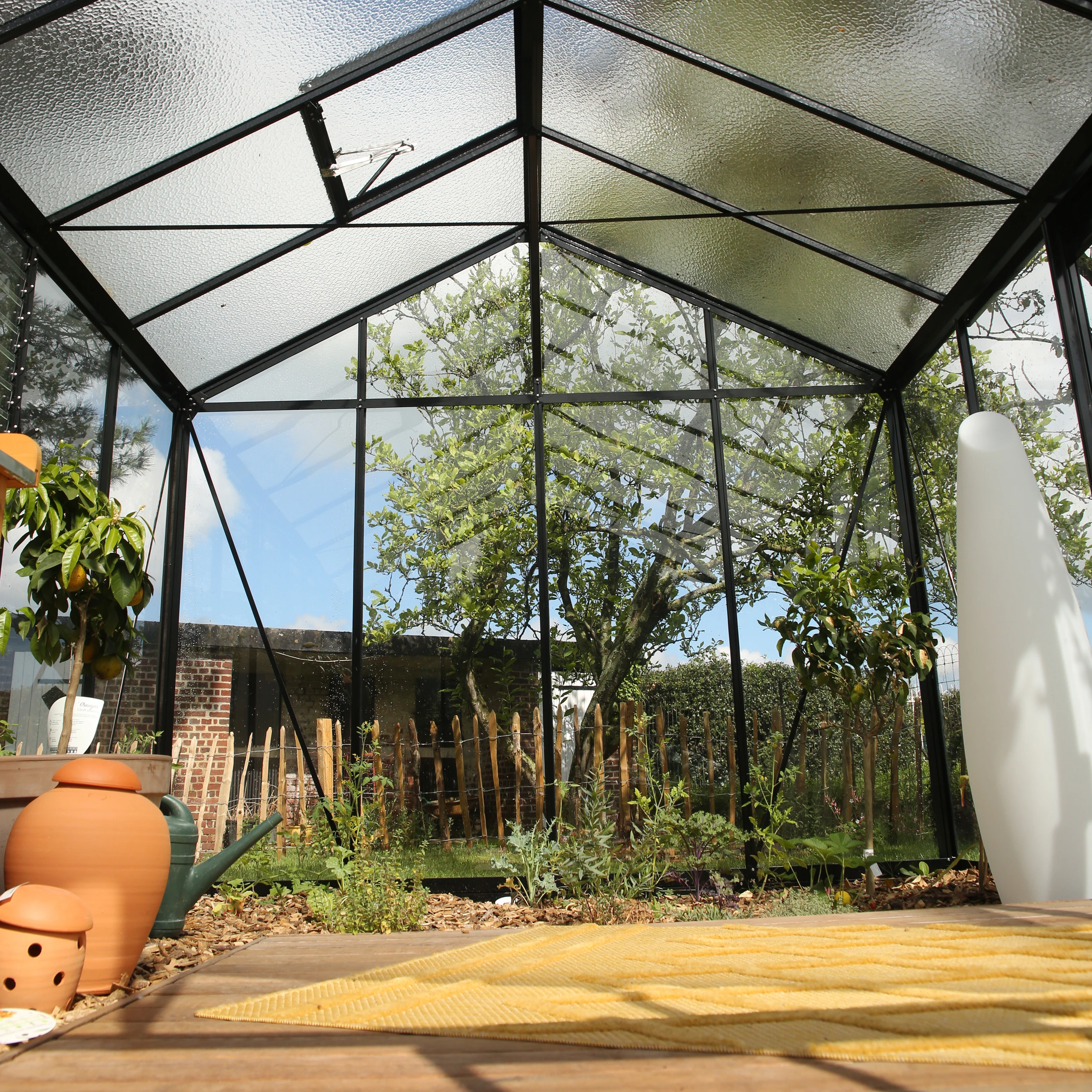 Vue intérieure d'une serre en verre trempé avec plantes cultivées et lumière naturelle zénithale à Noyon — Colver