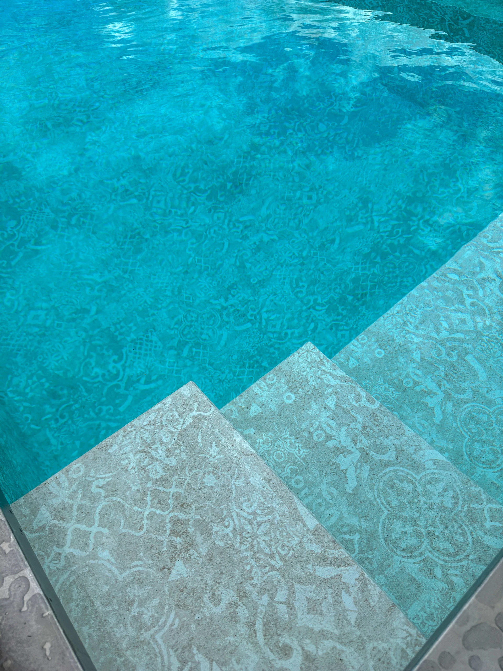 Détail liner piscine motif azulejos avec marches immergées et eau turquoise cristalline à Saint-Quentin — Colver