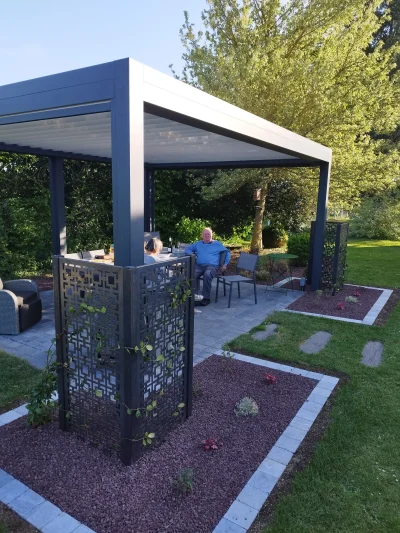Pergola bioclimatique aluminium anthracite avec claustra décoratif et terrasse pavée — Colver Créateur de Jardin