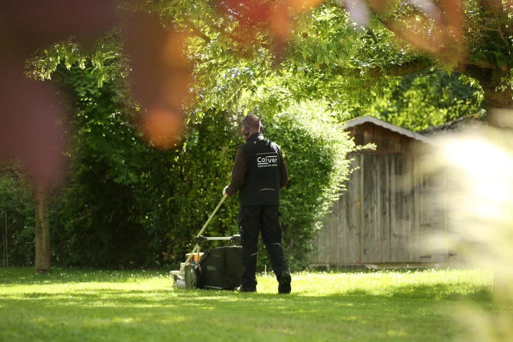 Technicien Colver tondant une pelouse dans un jardin arboré — entretien jardin Oise