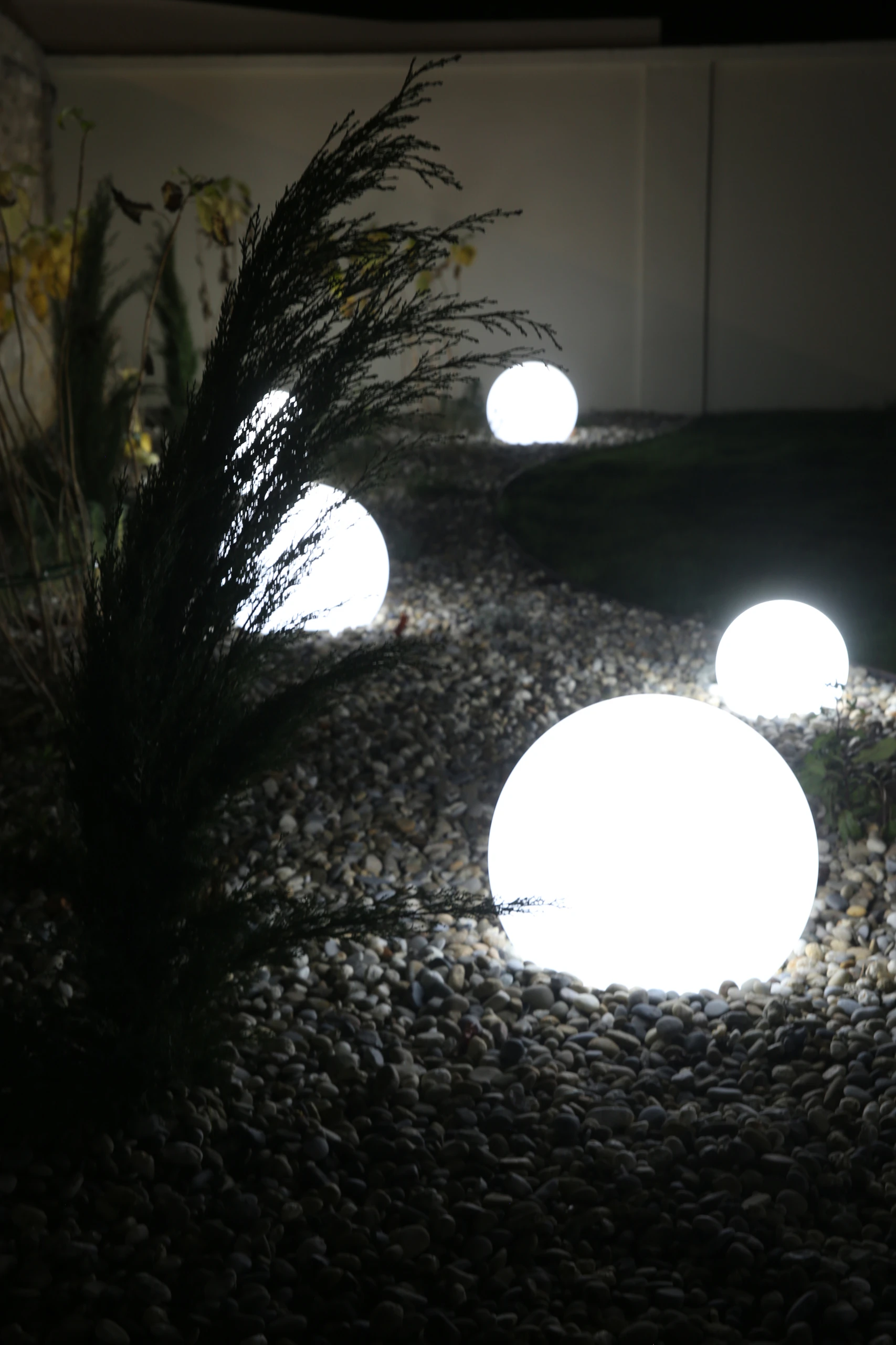 Boules lumineuses LED blanches posées sur massif de galets pour un éclairage décoratif de jardin à Margny-lès-Compiègne — Colver