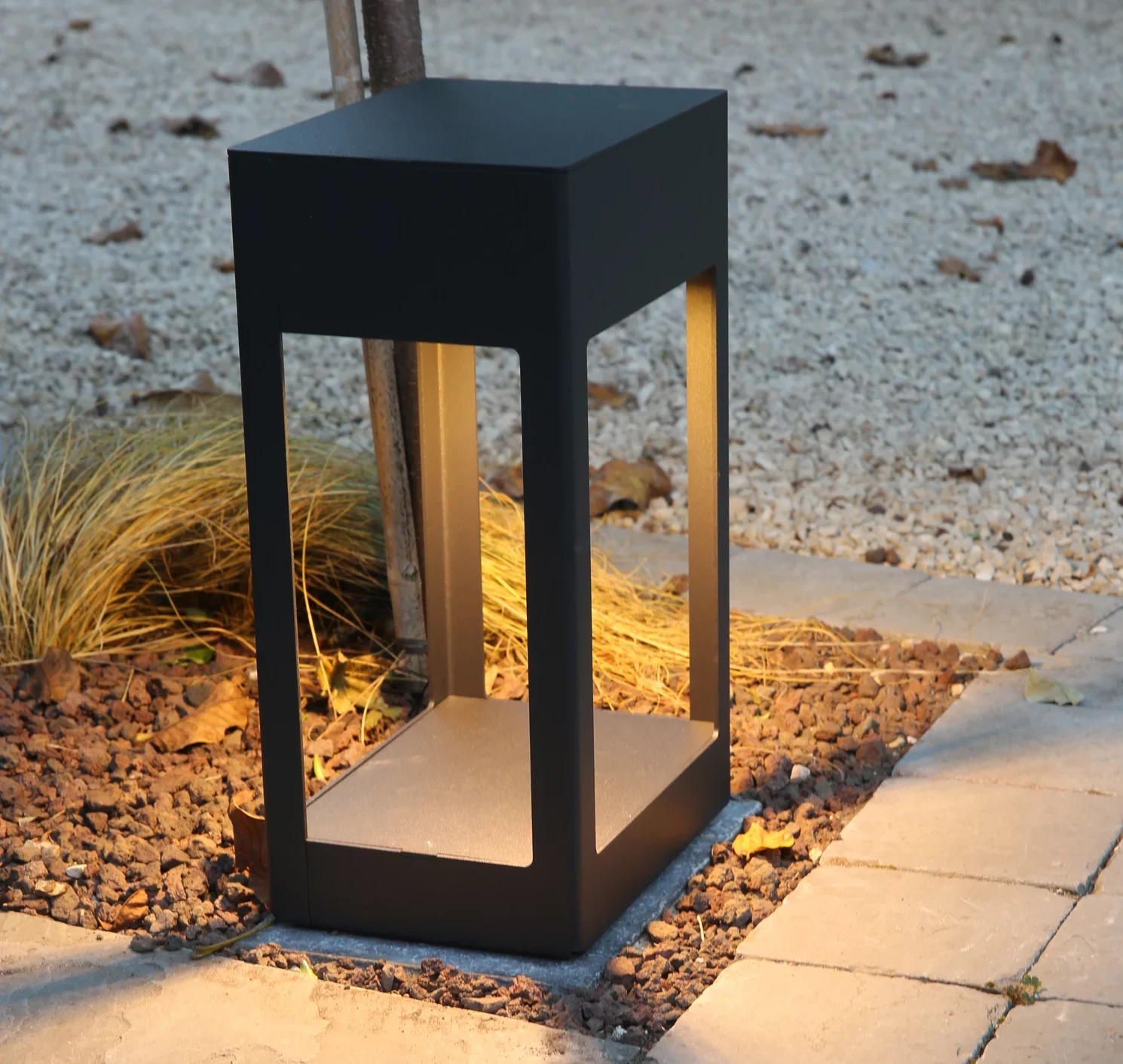 Lanterne LED moderne noire posée en bordure d'allée pavée, éclairage extérieur élégant à Thourotte — Colver