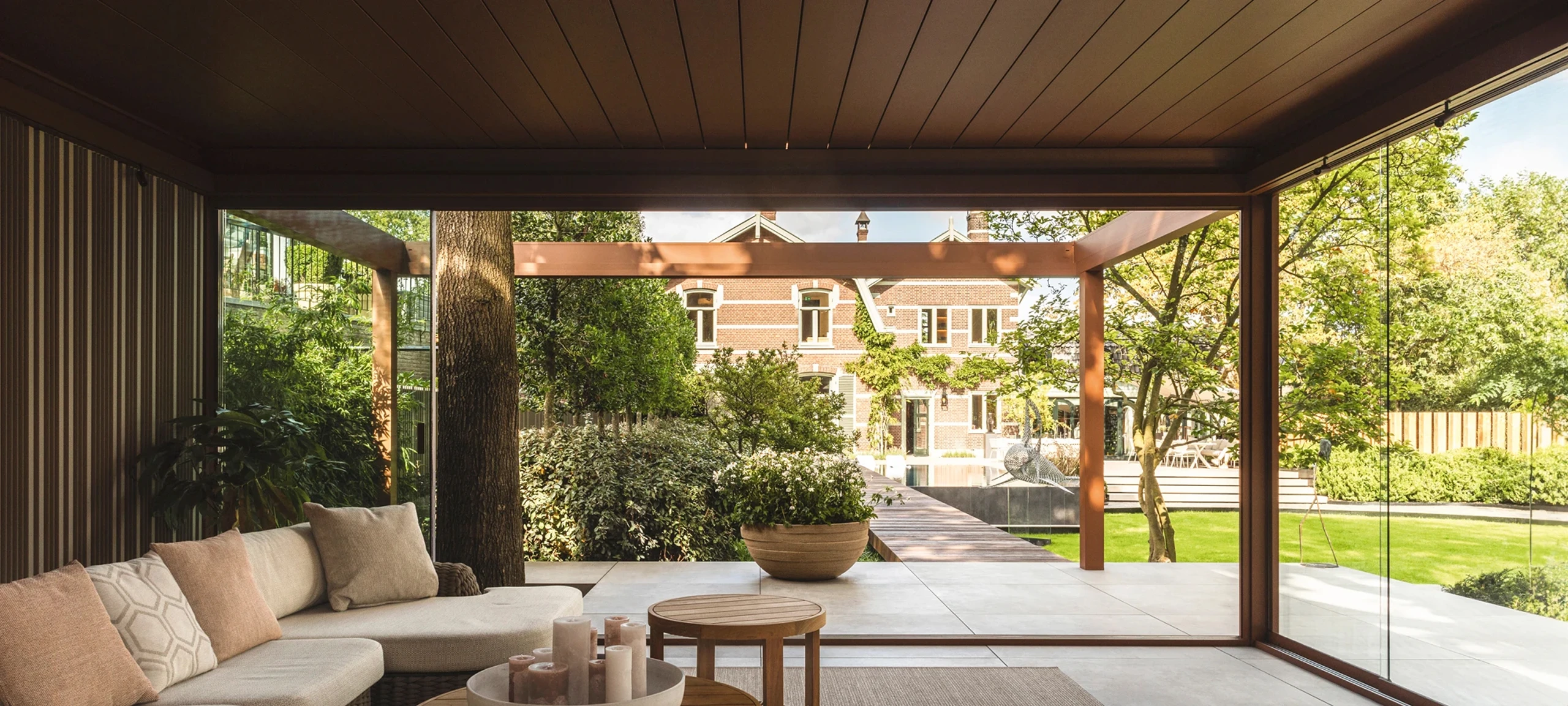 Pergola bioclimatique haut de gamme avec parois vitrées coulissantes et salon extérieur aménagé à Crépy-en-Valois — Colver