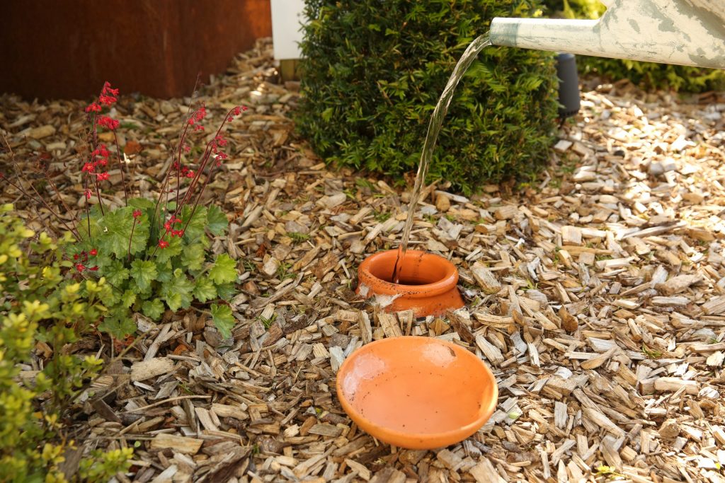 olla et poterie d’irrigation enterrés dans un massif