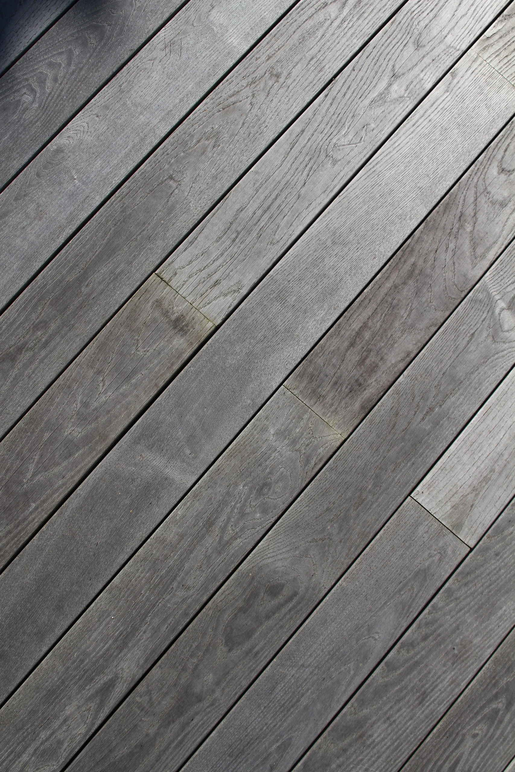 Détail de lames bois thermofrêne gris posées en diagonale sur terrasse — Noyon, Oise — Colver