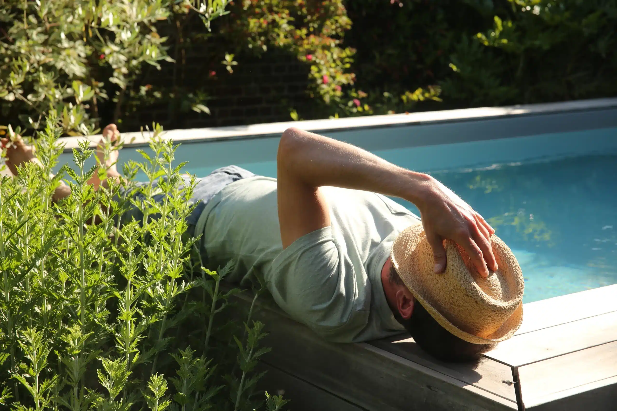 Détente en bord de piscine sur plage bois entourée de massifs fleuris — Compiègne, Oise — Colver