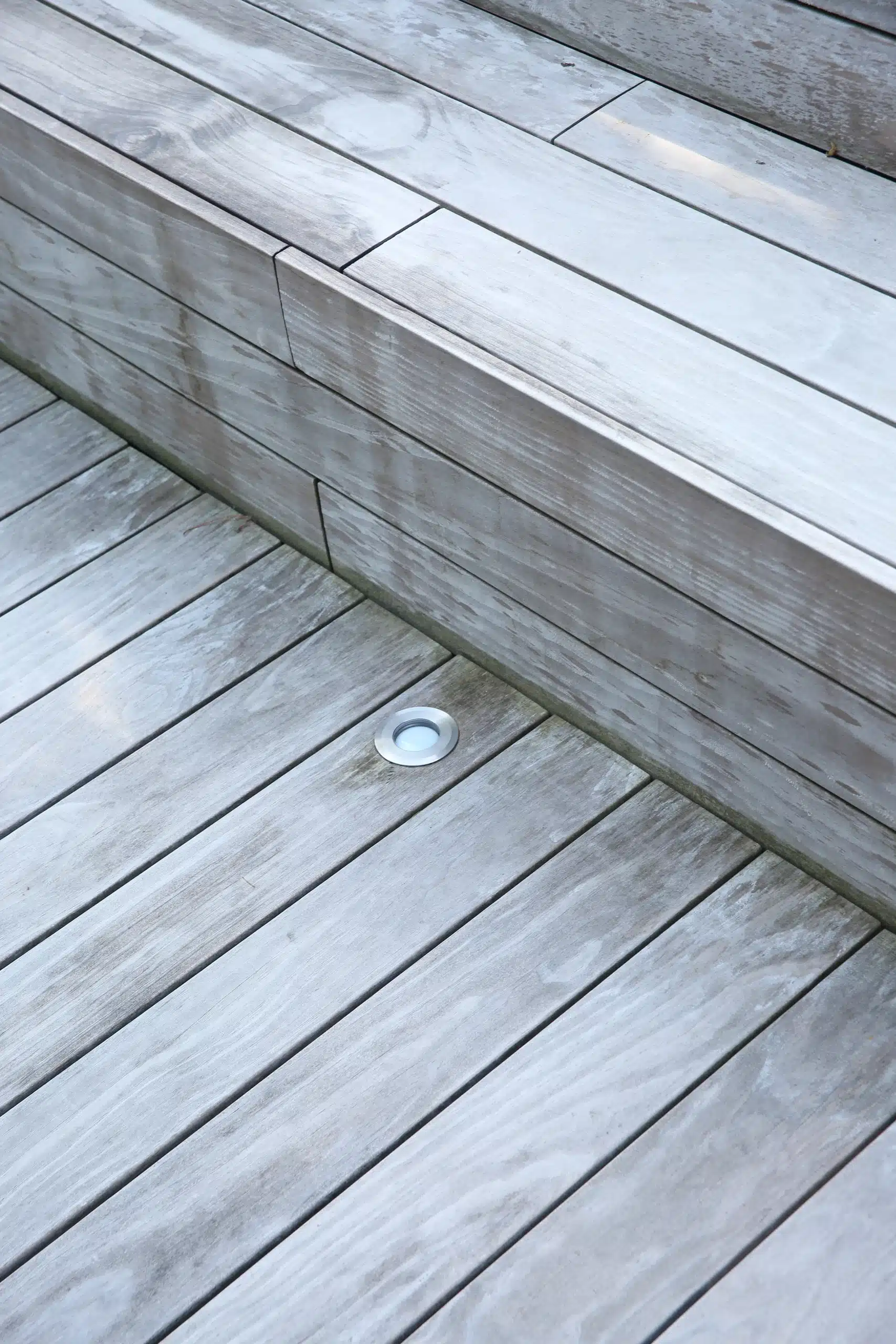 Détail spot LED encastré au sol sur terrasse bois grisée à niveaux — Compiègne, Oise — Colver